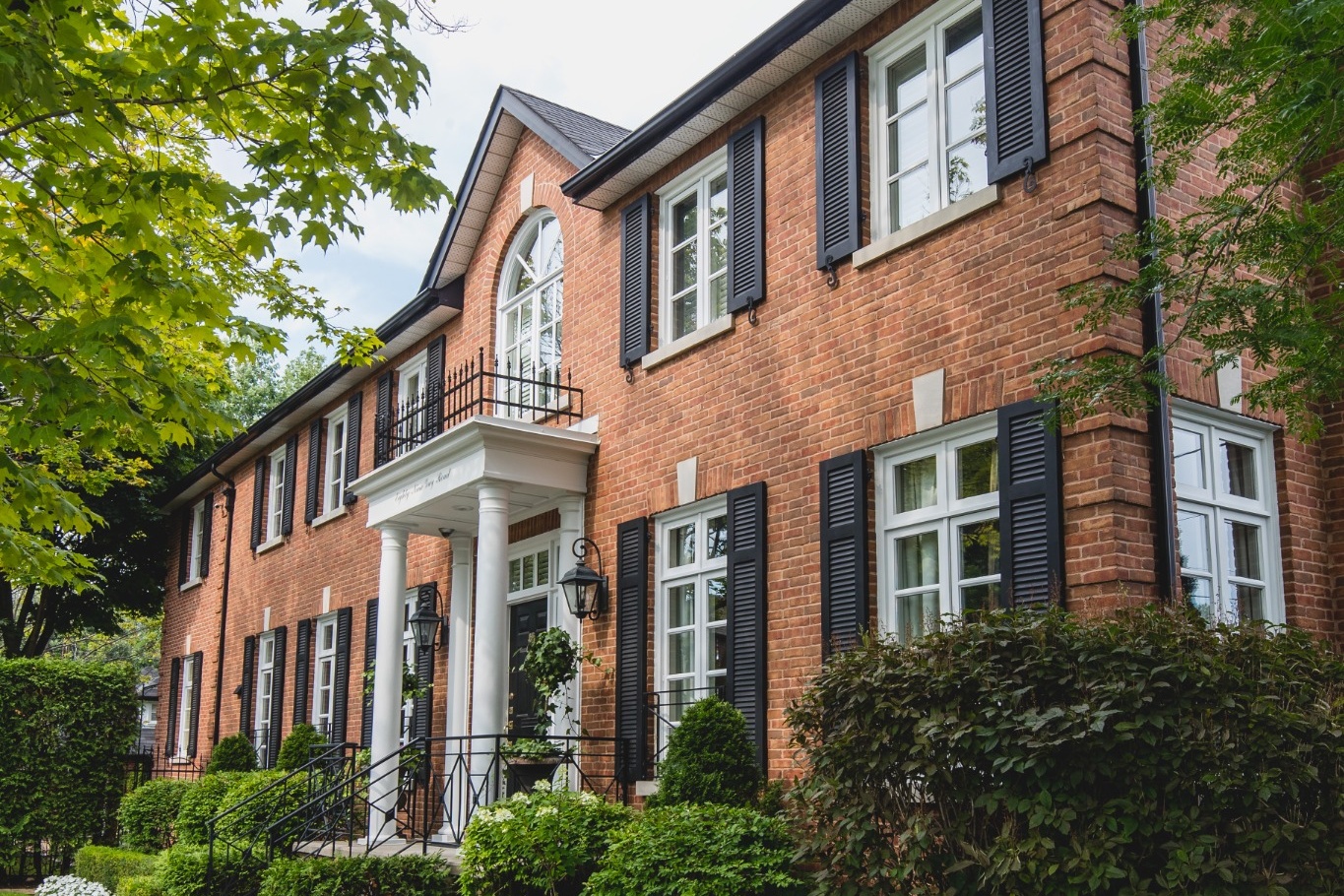 Traditional brick home with custom louvered exterior shutters