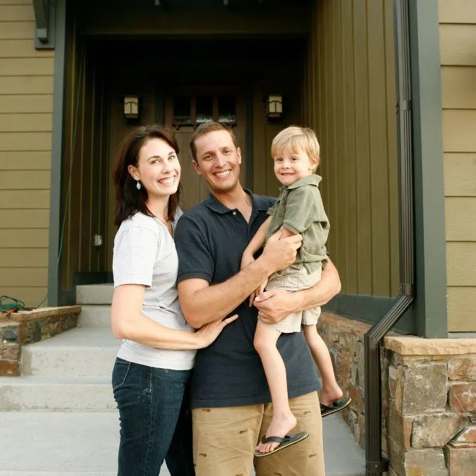 Happy family standing in front of their home after working with Double Advantage Business Services to avoid foreclosure and secure a fresh start