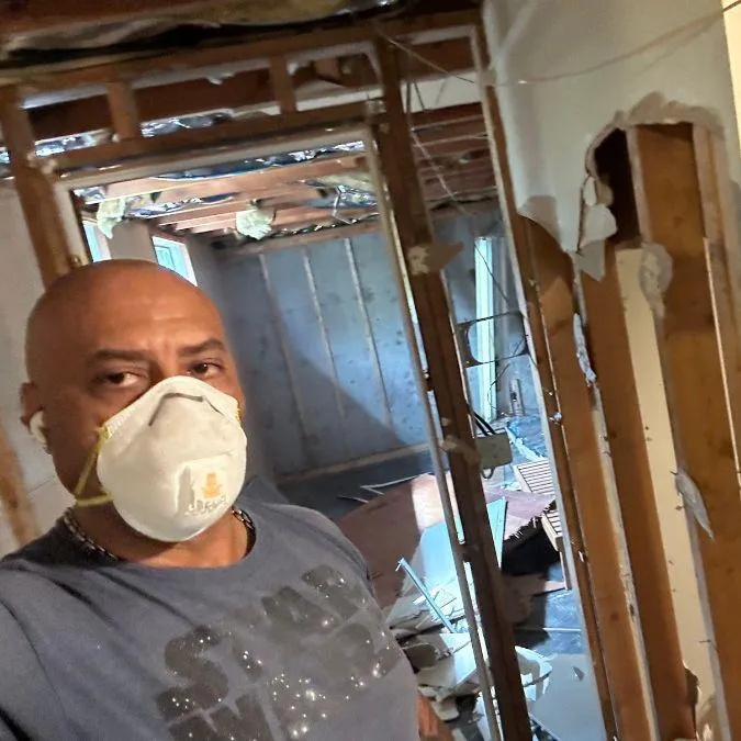 Charles Massey, owner of Double Advantage Business Services, inside an active residential demolition site during a full rehabilitation project