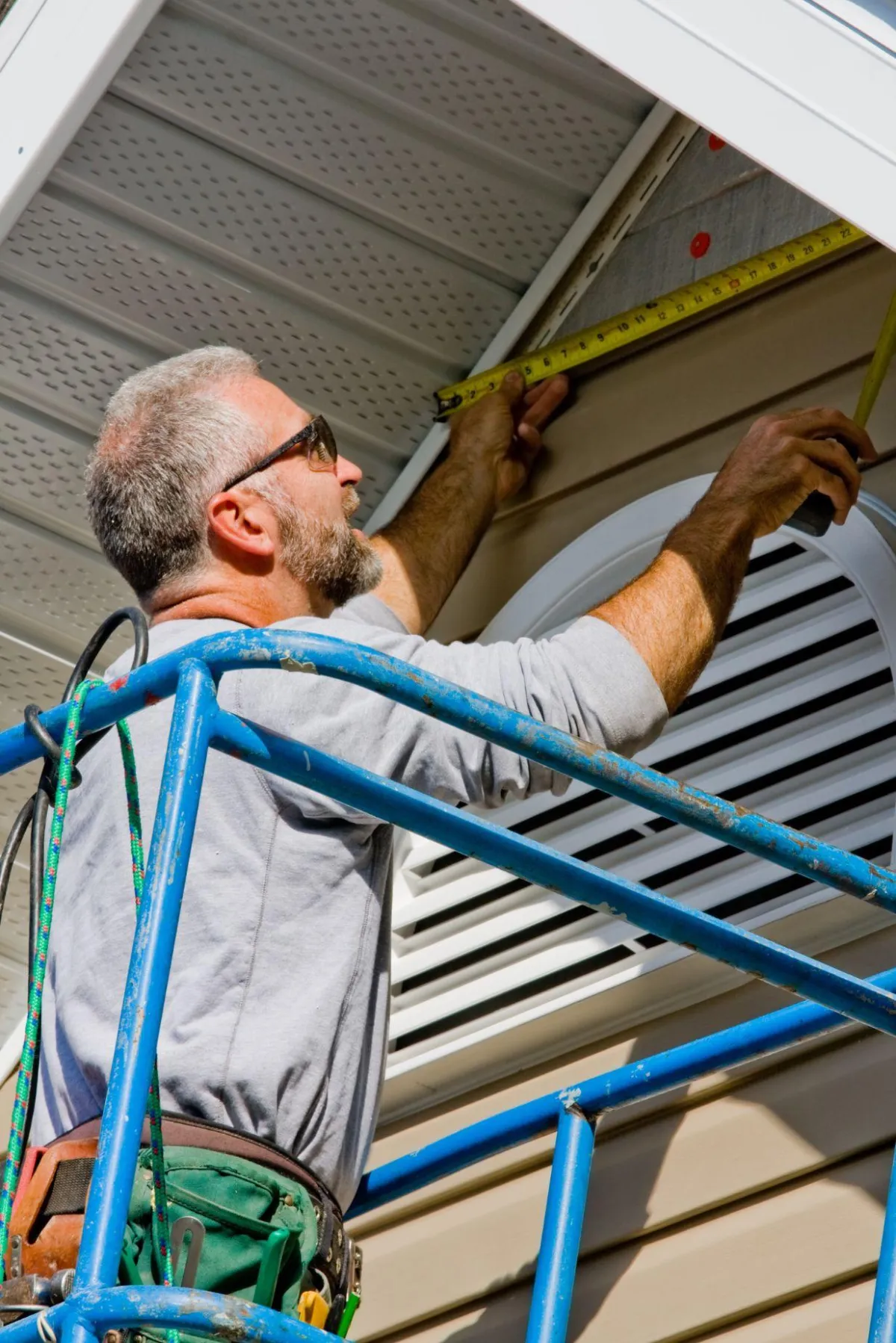 Contractor measuring siding and trim during an exterior remodeling project for a residential home