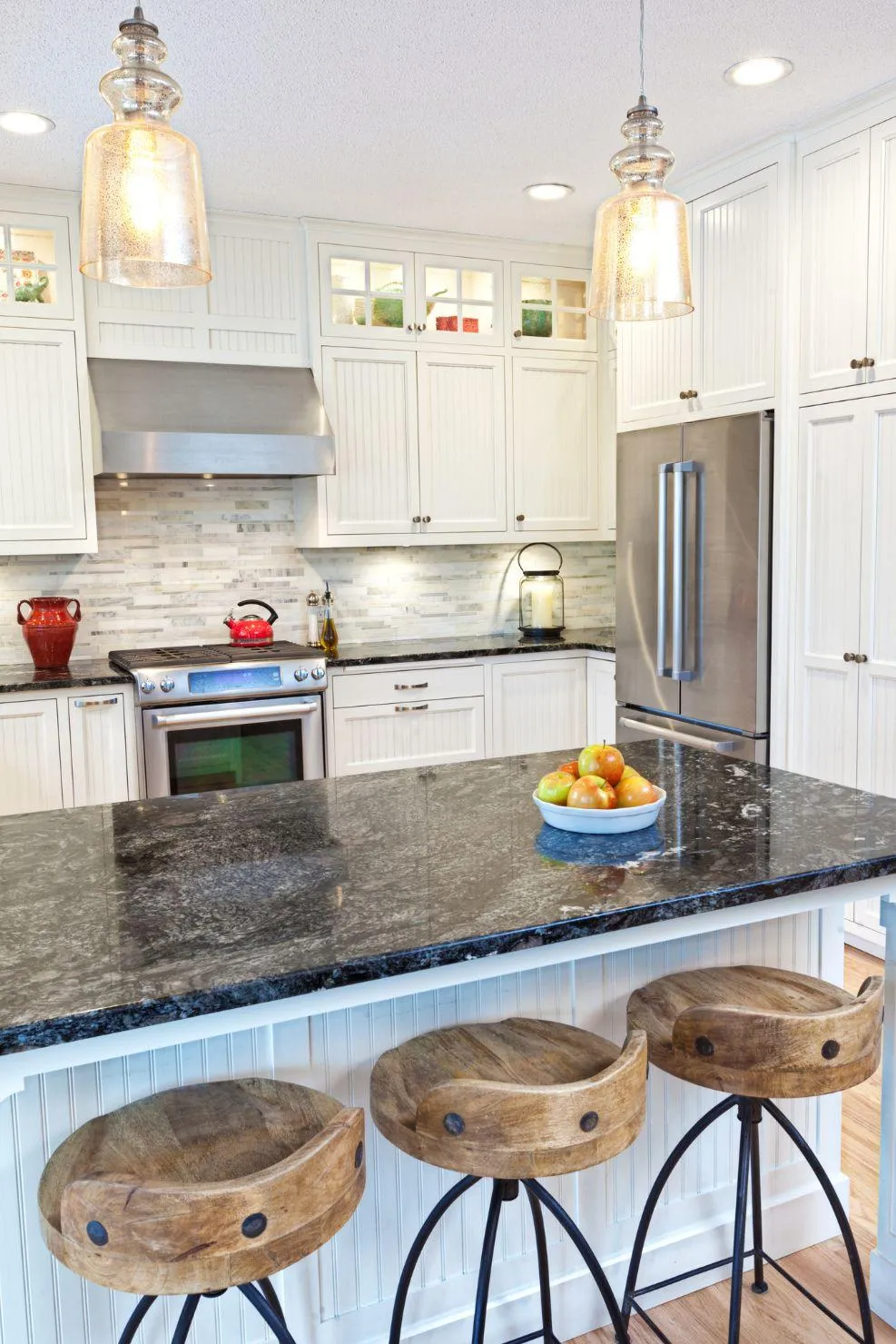Modern kitchen interior featuring white cabinetry, stainless steel appliances, and a granite island remodeled by Double Advantage Business Services