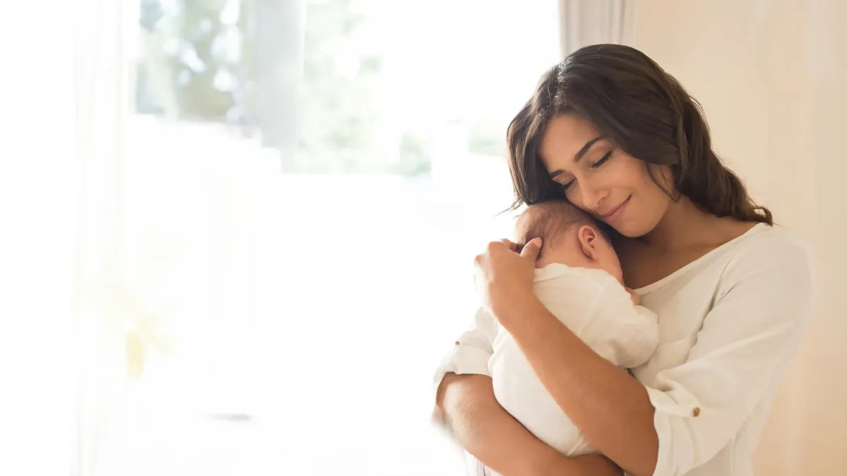 Mother holding her baby after conceiving naturally