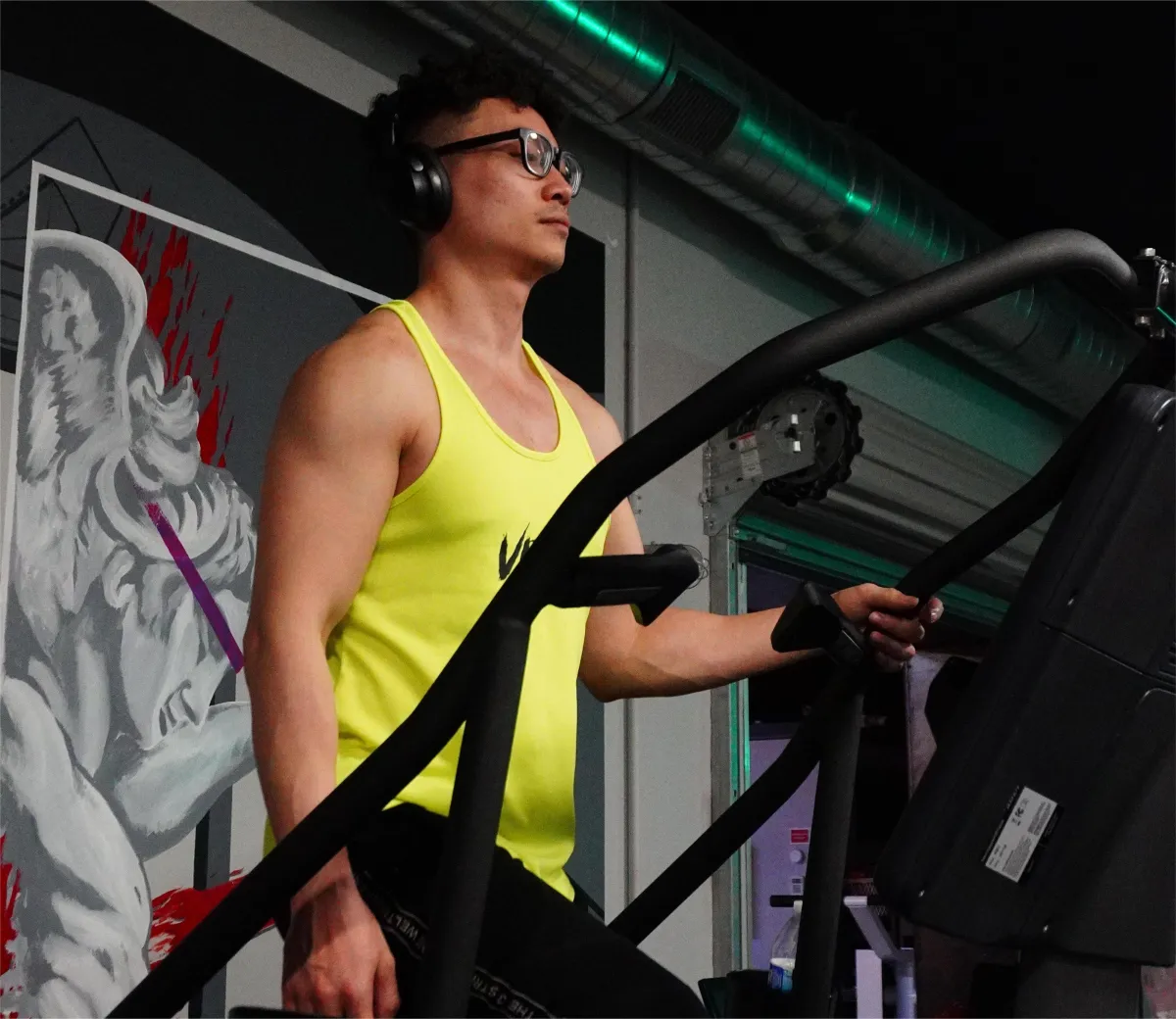 person in gray shirt holding black dumbbell