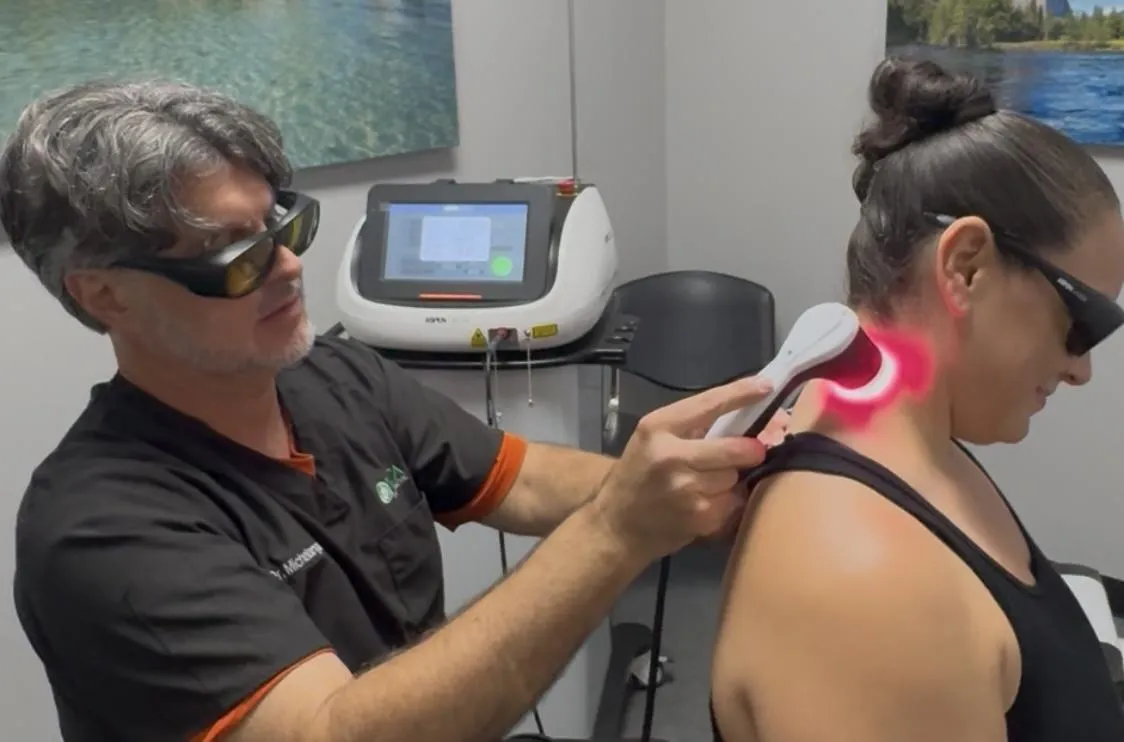 Chiropractor using advanced laser therapy on patientβs neck at Vita Chiropractic