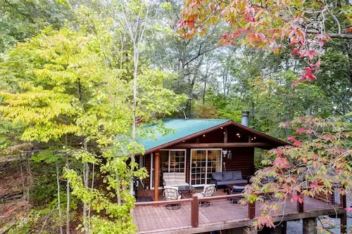 log cabin in the woods with fall oliage