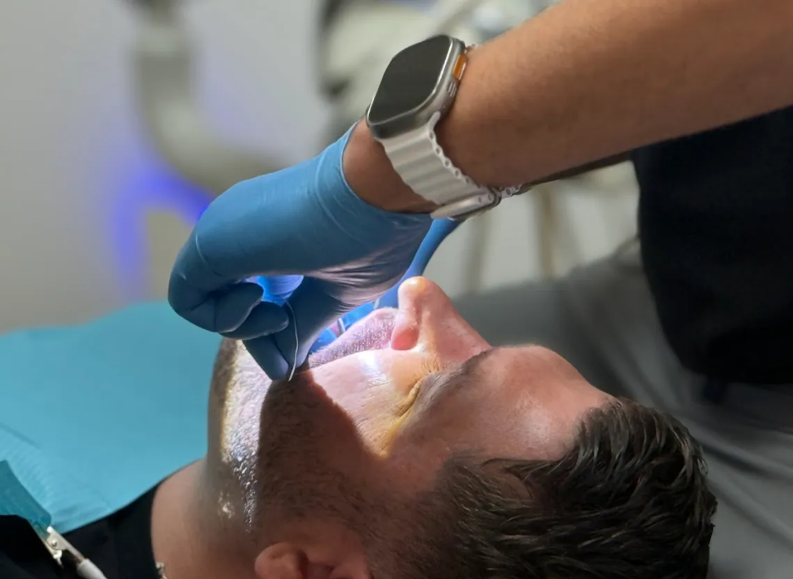 a toothbrush with a toothpaste on it next to a bowl of tooth