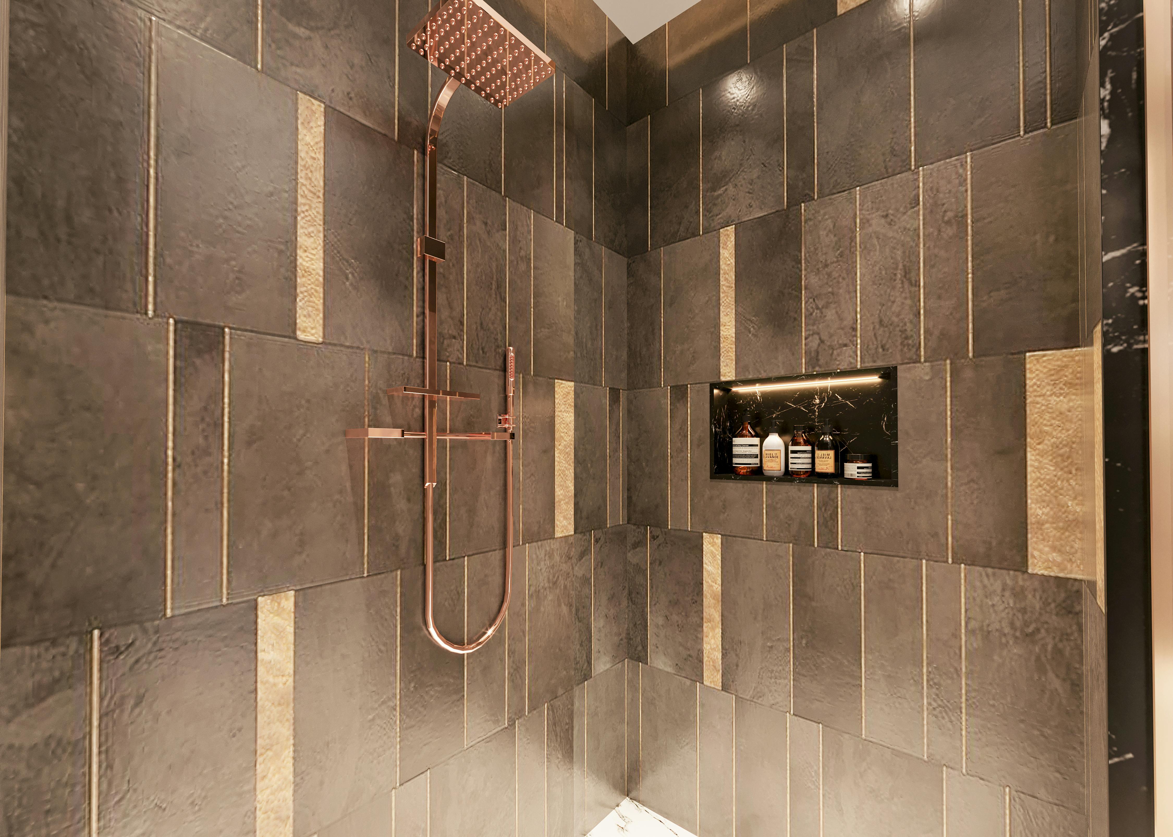 black tiled shower space with a brass shower head and valve
