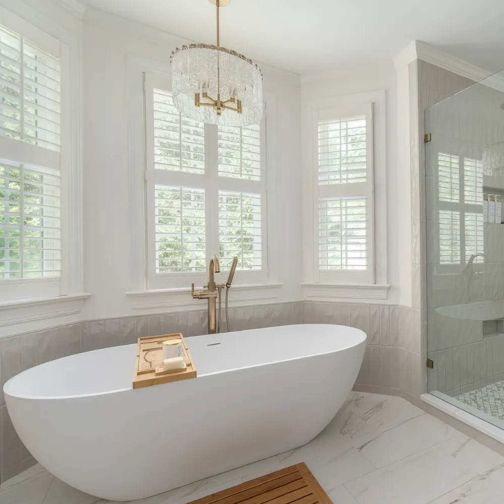 Luxury bathroom renovation featuring marble tile and freestanding tub