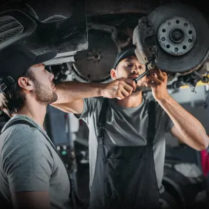 Mechanic inspecting a vehicle's braking system, focusing on brake pads, rotors, and fluid maintenance for safe stopping power.