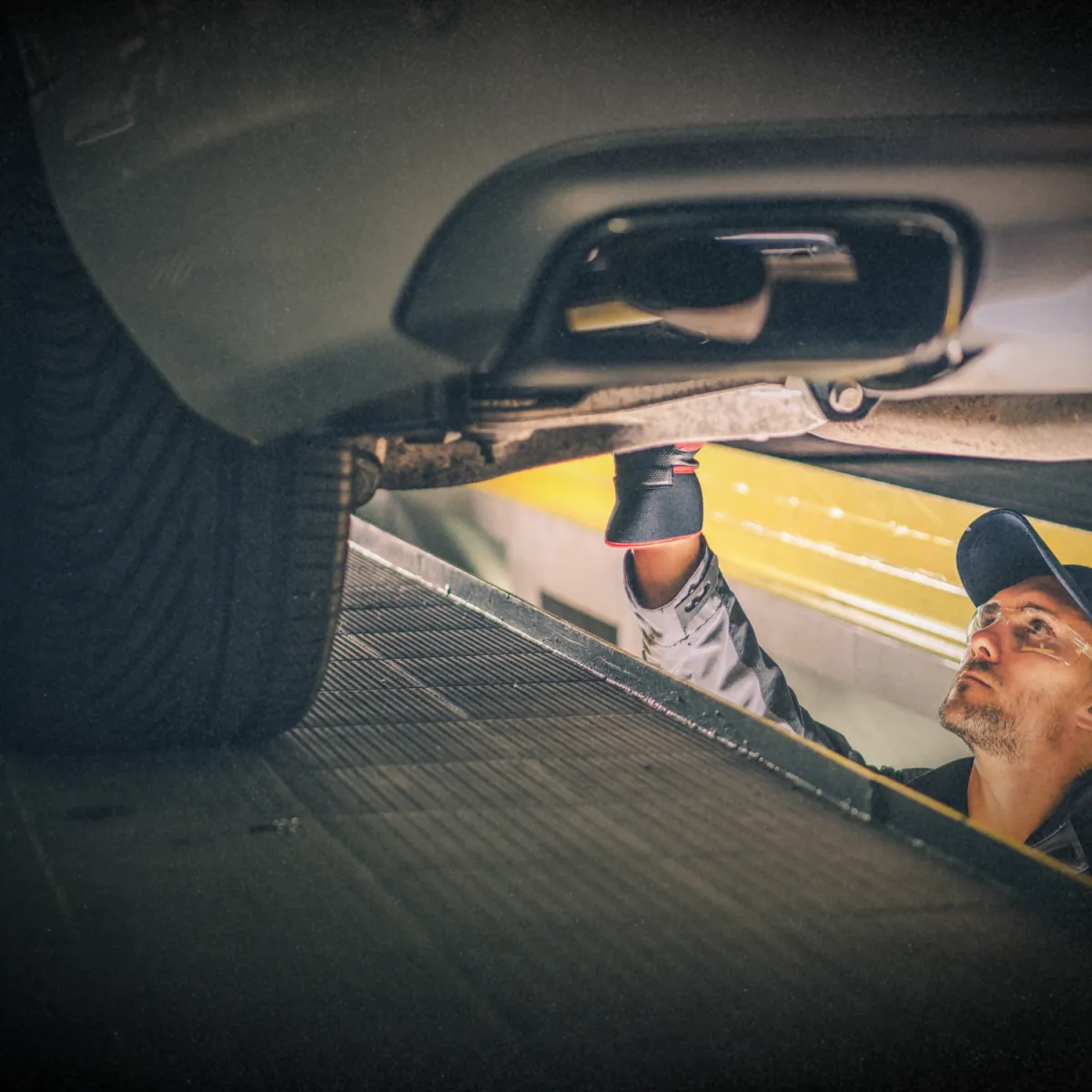 Mechanic inspecting car engine for transmission and drivetrain service