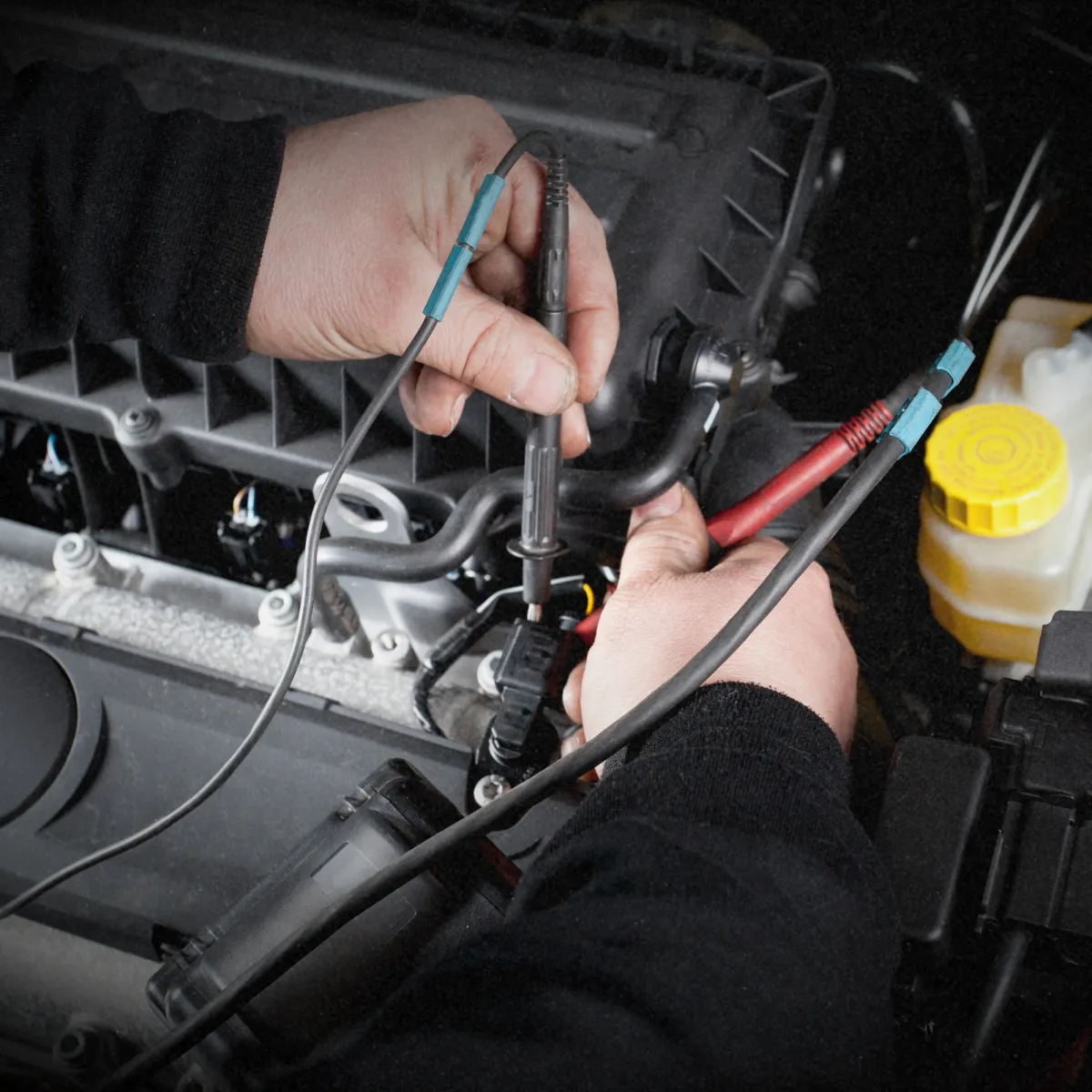 Mechanic inspecting car engine for transmission and drivetrain service