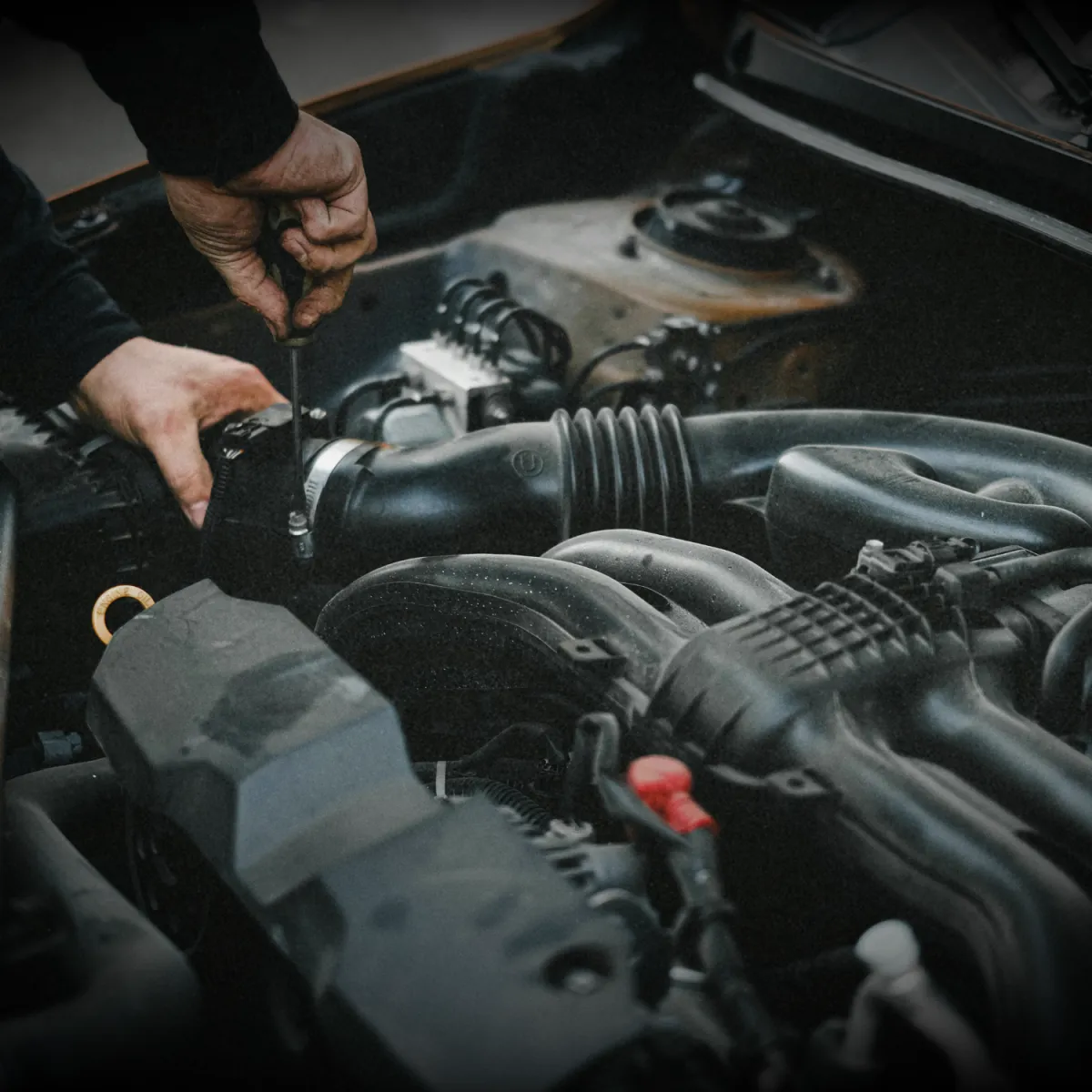 Mechanic inspecting car engine for transmission and drivetrain service