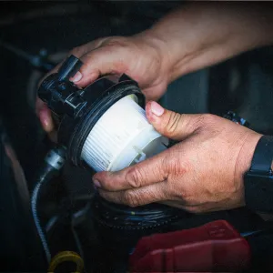 Mechanic replacing a car fuel filter, ensuring a clean and efficient filtration system for optimal engine performance.