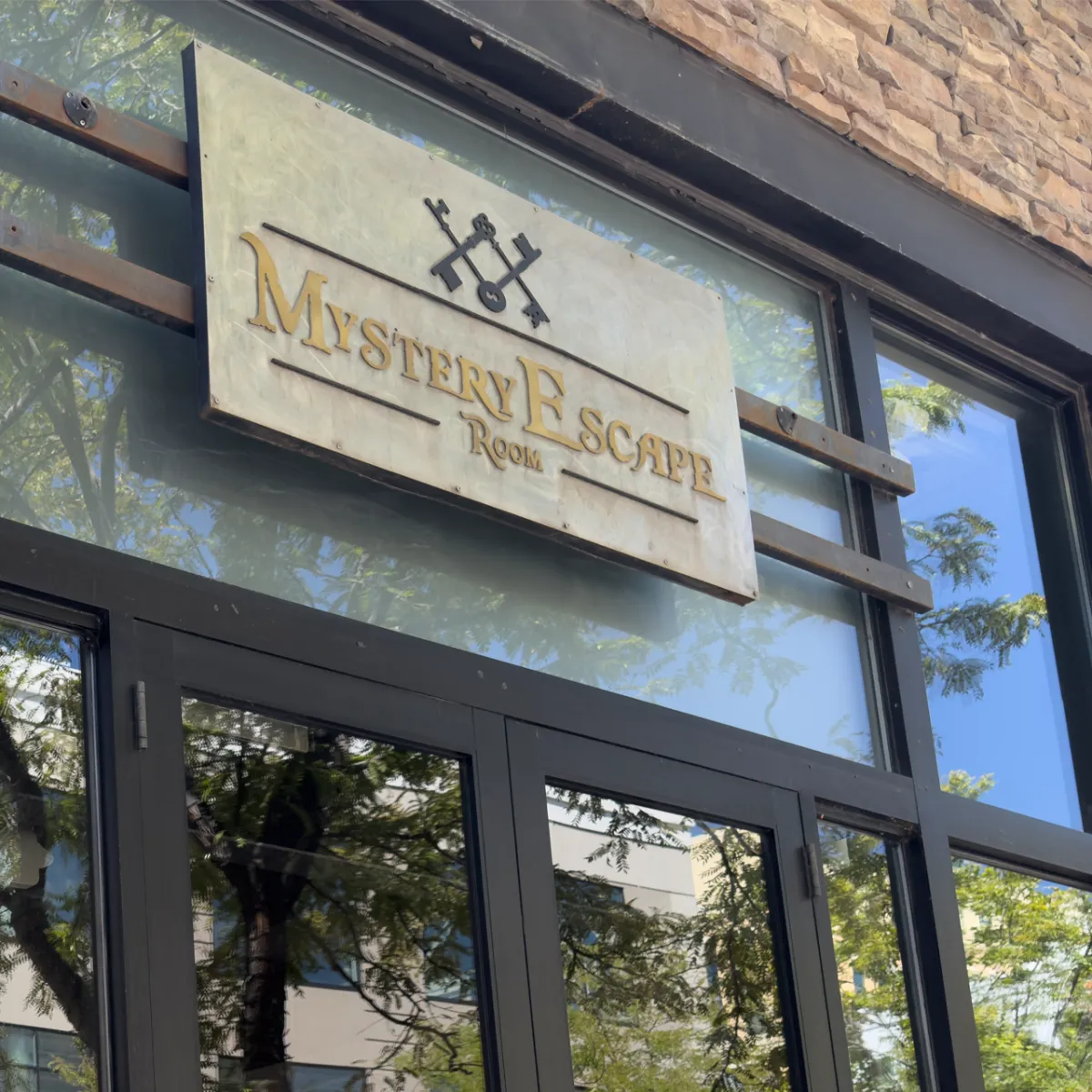 Wide view of a Salt Lake City themed escape-room corridor with layered props, warm tungsten lighting, and a dramatic vanishing point that suggests adventure and a family-friendly atmosphere.