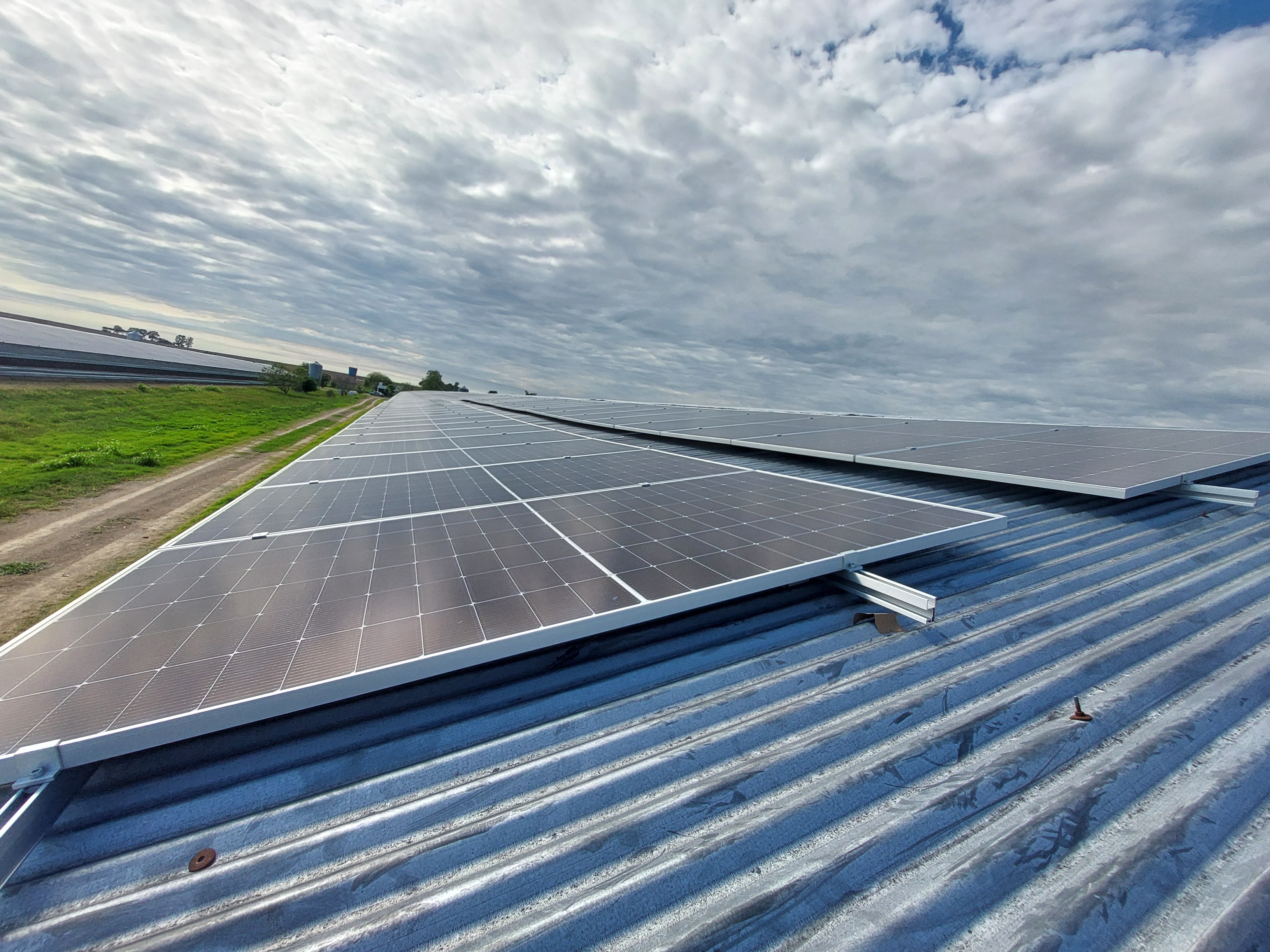 Instalación solar en vivienda de Posadas, Misiones, adultos mayores conversando en la galería, cielo despejado