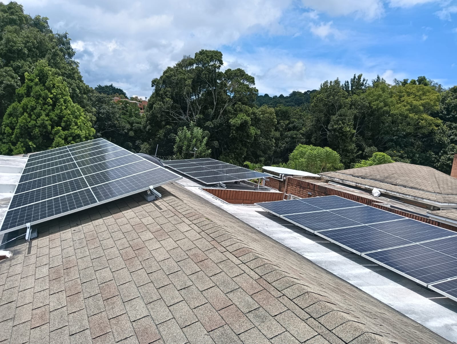 Paneles solares en techo de casa moderna en Corrientes, pareja joven regando plantas, luz cálida de atardecer