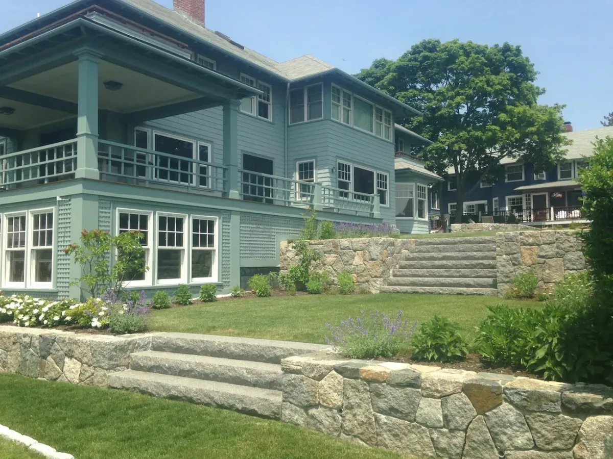 Custom stone retaining walls and granite stair installation in Marblehead MA residential landscape design.