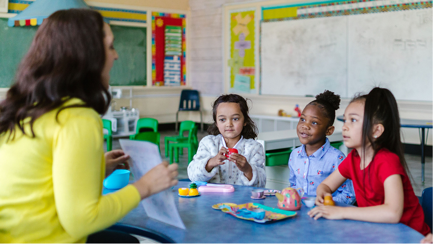 Teacher engaging children in a hands-on classroom activity