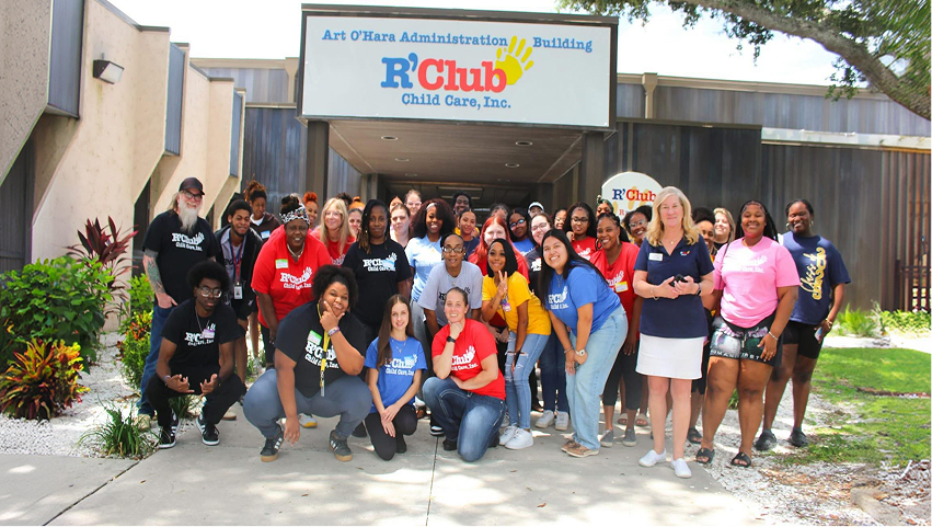 Group of students and teachers posing together outdoors