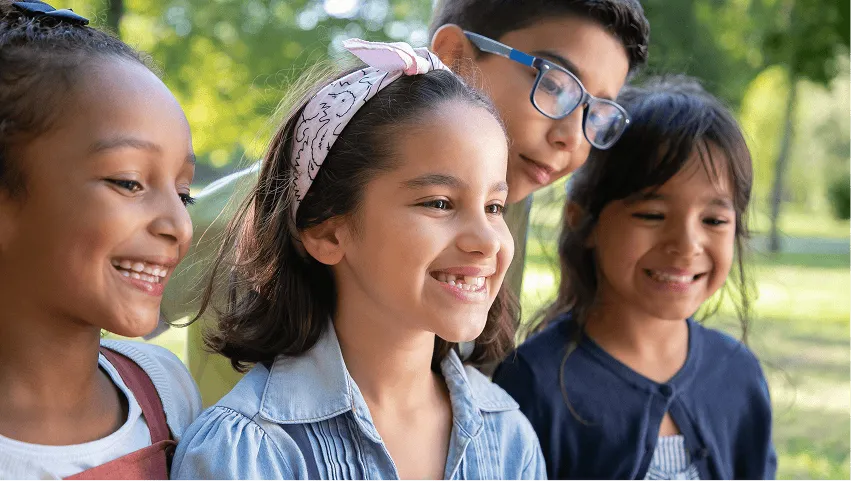 Three students smiling together outdoors