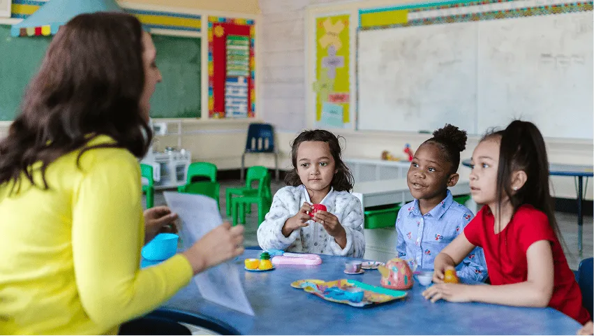 Teacher engaging children in a hands-on classroom activity