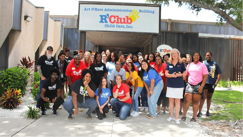 Group of students and teachers posing together outdoors