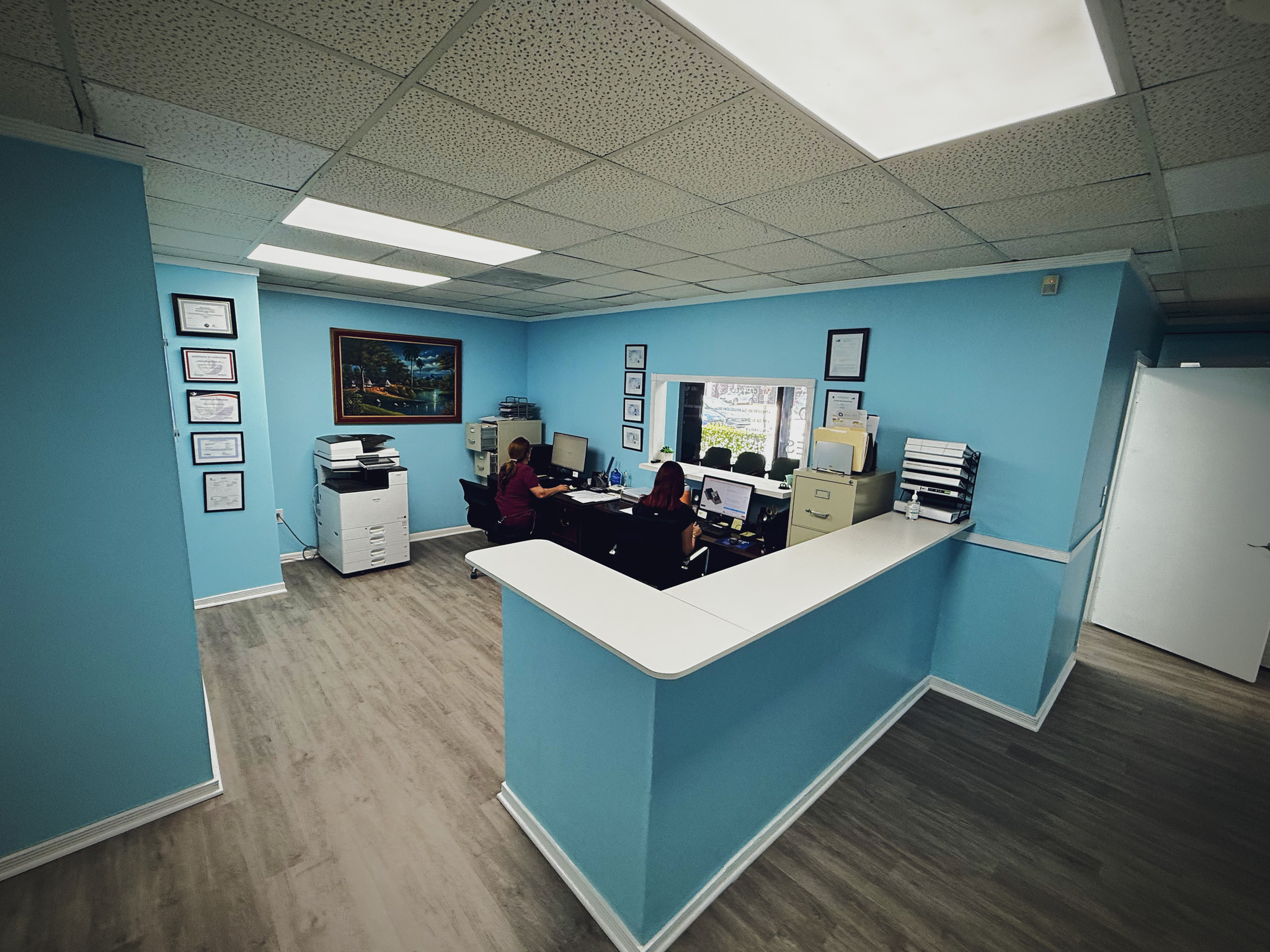 Mostrador de recepción con computadoras y espacio de trabajo administrativo