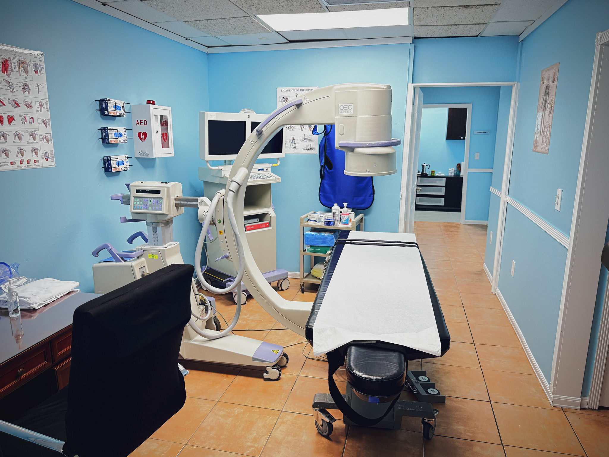 Vista frontal de la camilla y el equipo con arco en C en la sala de procedimientos