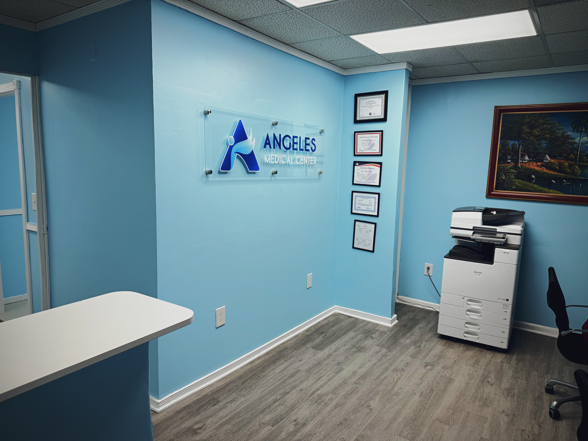 Área administrativa con el logotipo de Ángeles Medical Center y certificados en la pared