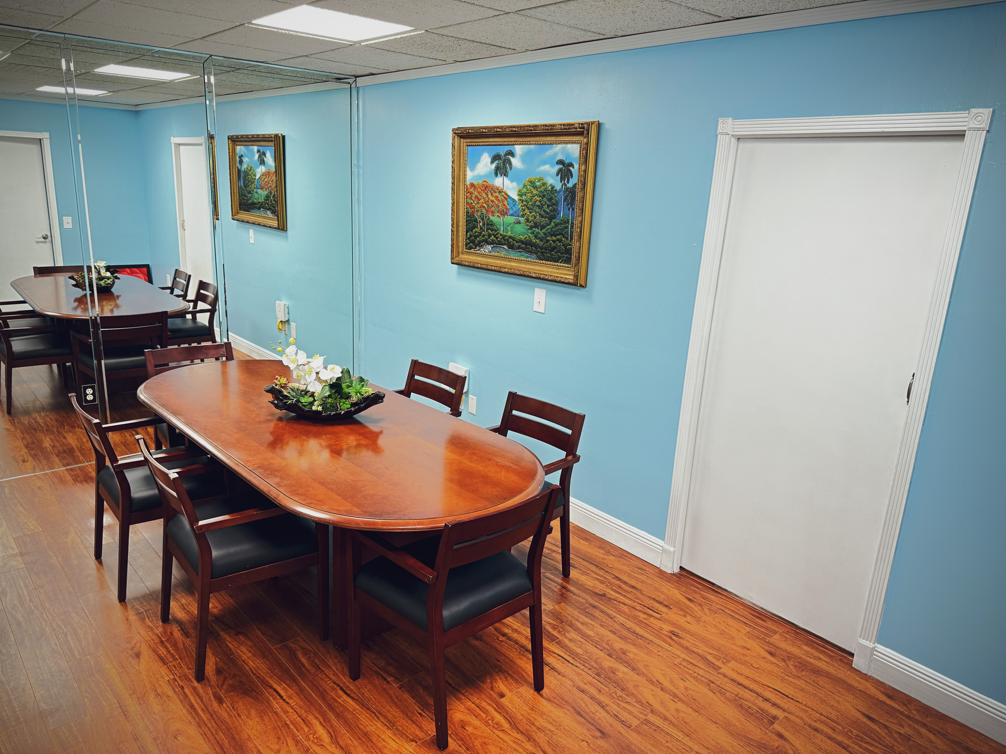 Sala interior con mesa de madera, sillas y cuadros decorativos