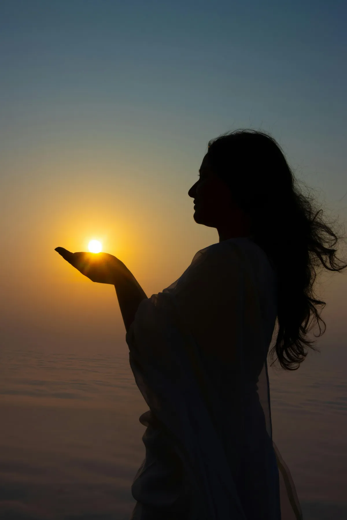 woman in shadow with the sun behind her hand