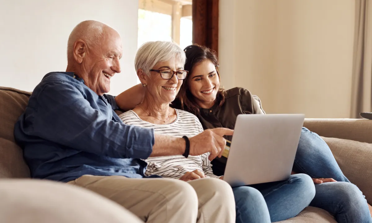 Senior couple smiling while meeting with a care advisor at home — discussing senior living options with EverCare Placement.