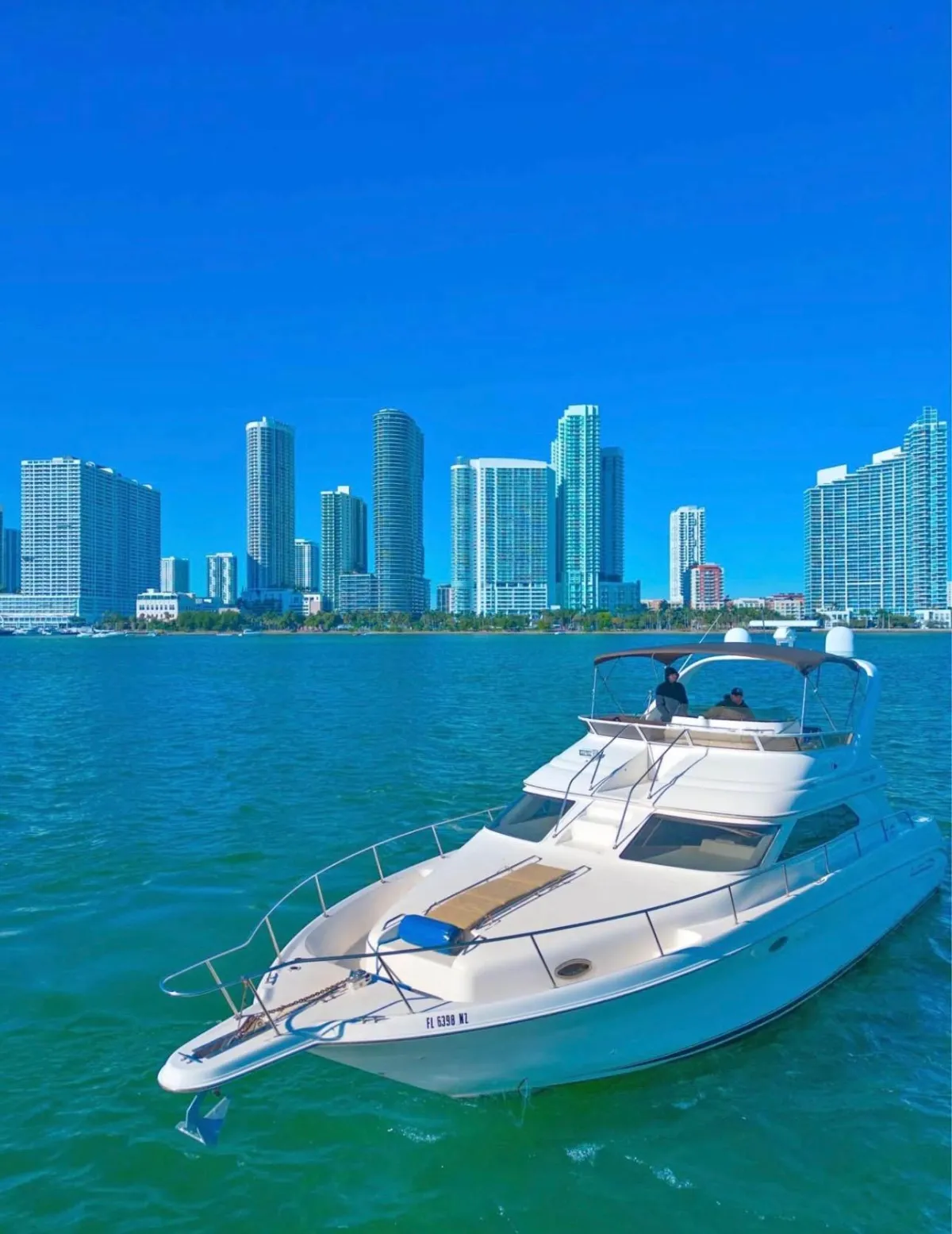 Front view of one of the yachts of the Elite Sports Yachts with the West Palm Beach on the background