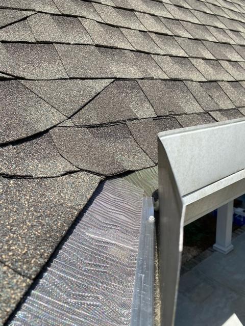 Close-up of newly installed grey gutters and downspout on a residential home by Collins Construction & Consulting LLC, gutter services Fort Stewart GA.