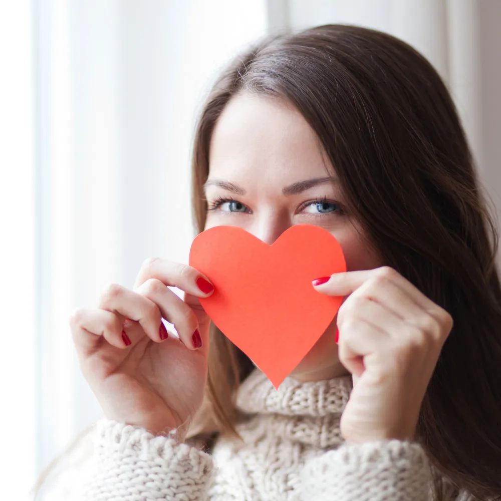 woman holding a heart, expressing self love