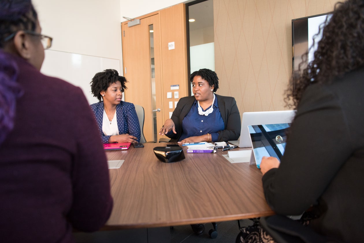Playful illustration of two Black women collaborating at a bright, welcoming workspace