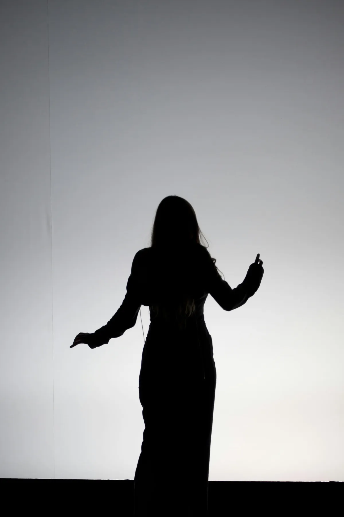 neutral background, featuring a subtle silhouette of a woman speaking