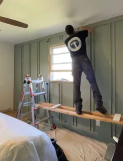 Handyman adding finishing touches to a stylish accent wall