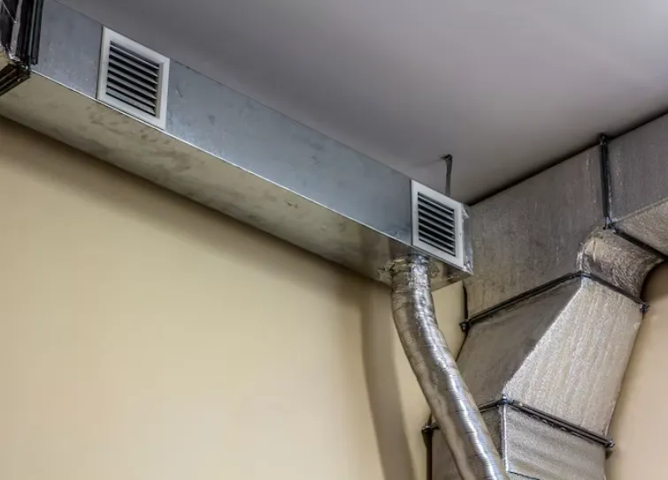 Industrial air duct ventilation equipment and pipe systems installed on industrial building ceiling.