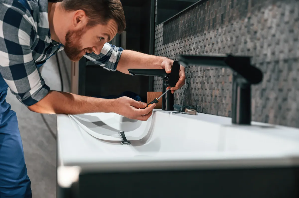 man fixing a leaky sink