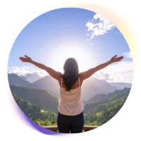 Mujer mirando al horizonte, con los brazos abiertos, dispuesta a soltar sus problemas.