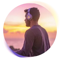 Hombre con auriculares y ojos cerrados, sentado en posición meditativa, sintiendo relajación.