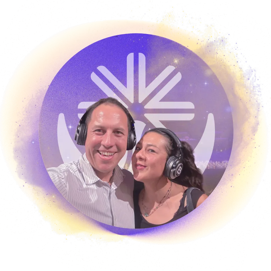 Gladys y Charlie abrazados felizmente sobre un fondo circular luminoso en tonos dorados y violetas con un símbolo gráfico de The breath path detrás de ellos.