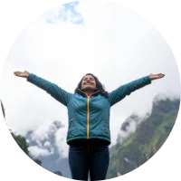 Persona con brazos abiertos en la naturaleza, simbolizando liberar tensiones y dejar ir a través de la respiración consciente.