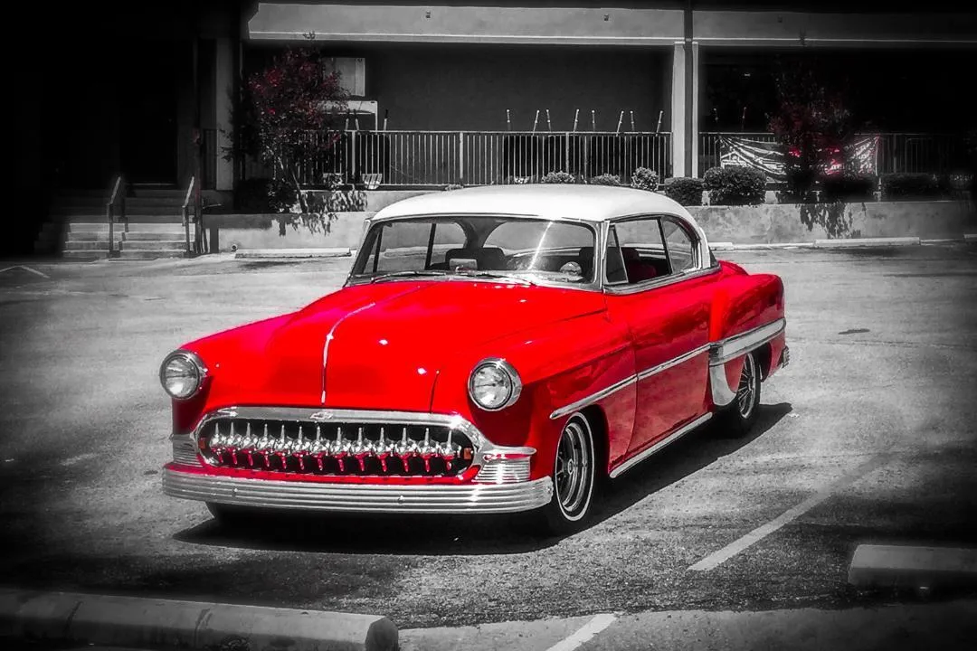 Polished red vintage car parked in a lot, illustrating vehicle style that may require inspection and title to drive legally in Texas.