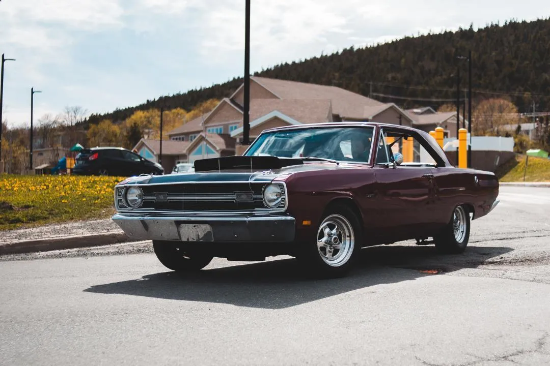 Vintage muscle car parked on a suburban street, representing key traits used by states to define and register classic vehicles.