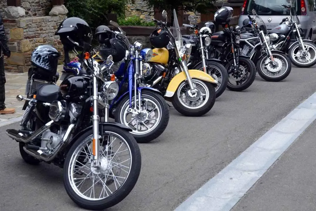 Row of parked motorcycles lined up on the street, representing state-by-state motorcycle street legal registration requirements.