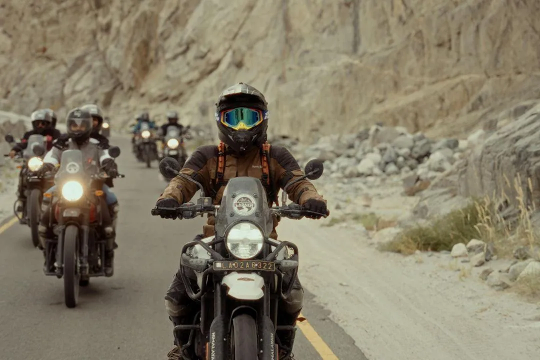 Group of motorcyclists riding through a rocky mountain road, illustrating steps to make a motorcycle street legal in Texas.