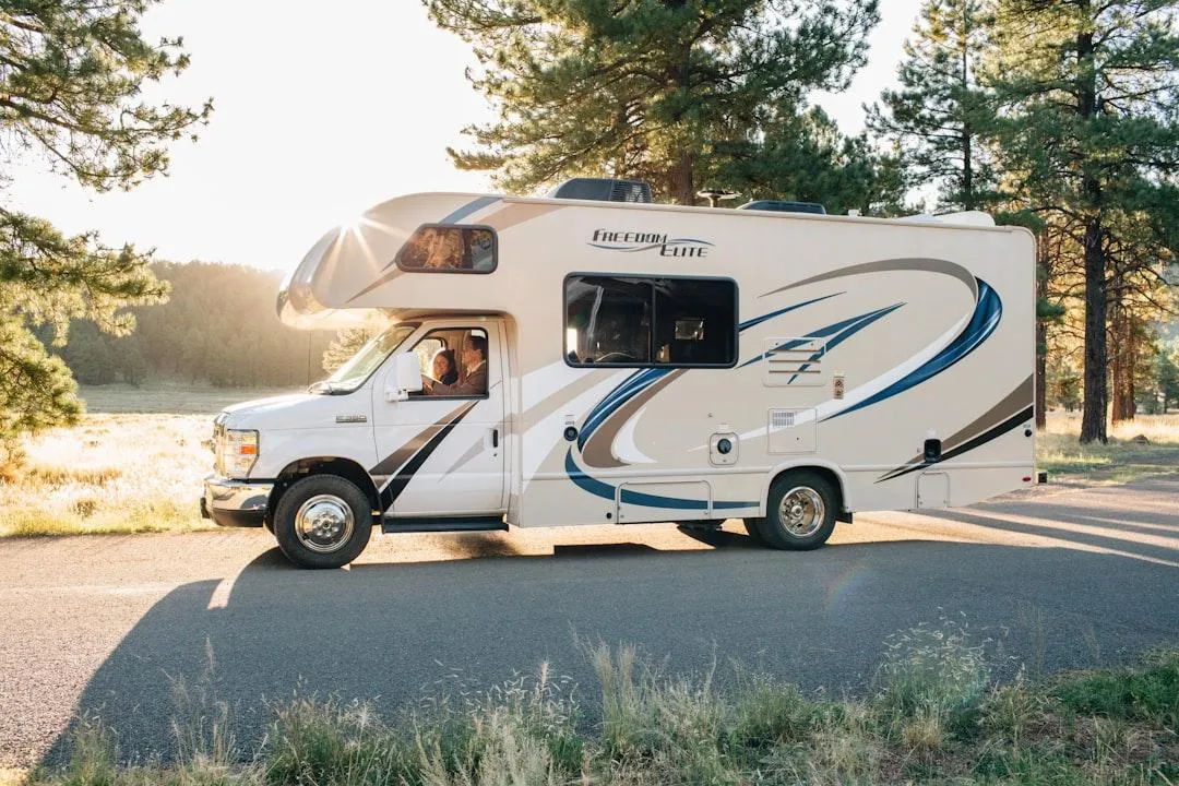 A rugged grey camper truck with large off-road tires stands on a white background.