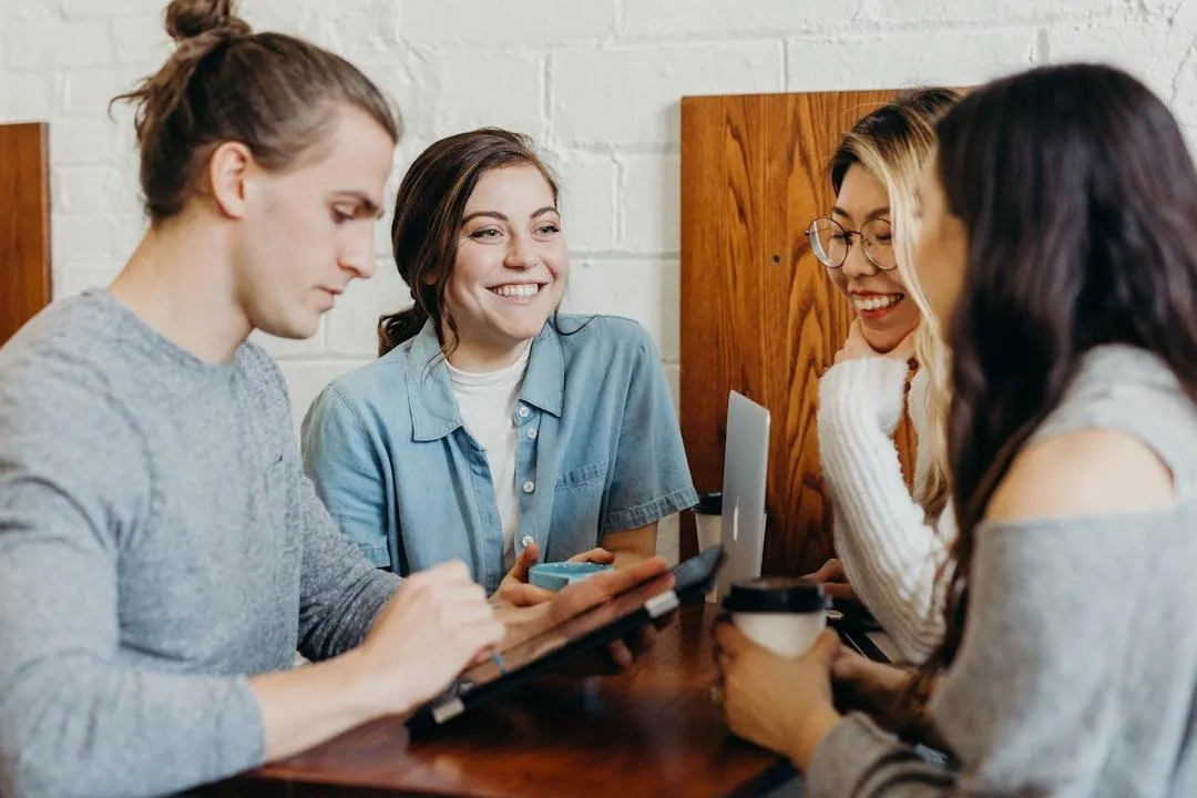 Four people sitting around a small table.